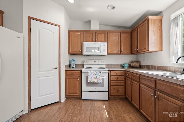1320 American Ln, Emmett, ID 83617 - kitchen featuring white appliances, a sink, brown cabinetry, lofted ceiling, and light wood finished floors