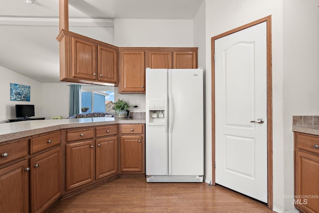 1320 American Ln, Emmett, ID 83617 - kitchen featuring white refrigerator with ice dispenser, brown cabinets, light countertops, and light wood-style flooring