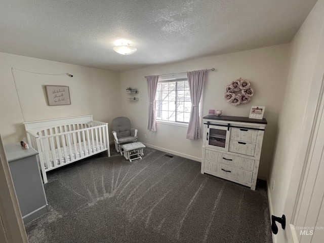 carpeted bedroom with a nursery area and a textured ceiling