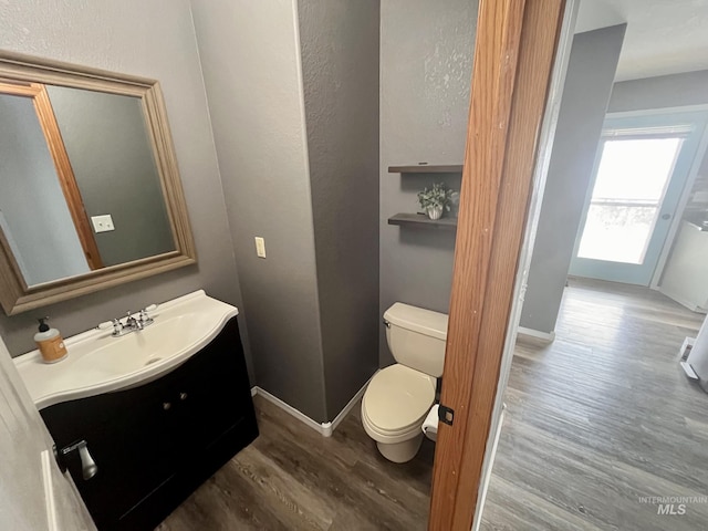 bathroom featuring wood-type flooring, vanity, and toilet