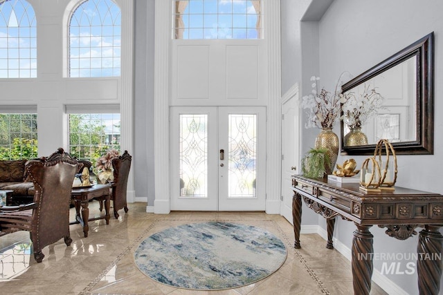 foyer with a towering ceiling and french doors