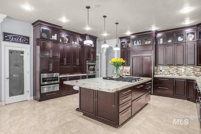 kitchen featuring a kitchen island, dark brown cabinetry, and decorative light fixtures