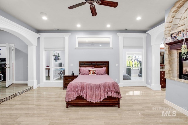 bedroom with a stone fireplace and ceiling fan