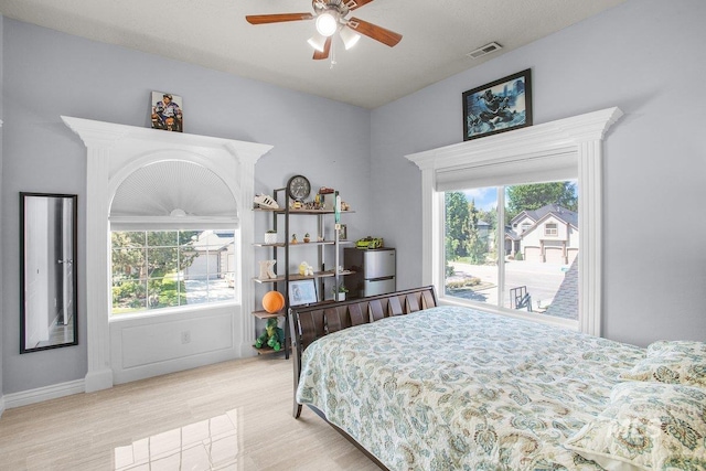 bedroom with ceiling fan, access to exterior, and multiple windows