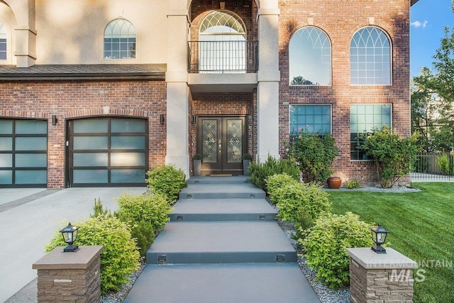 entrance to property with a garage, a yard, french doors, and a balcony