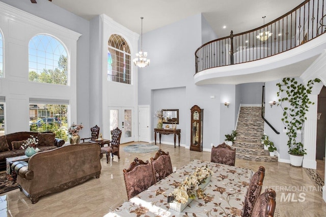 dining area featuring a towering ceiling and an inviting chandelier