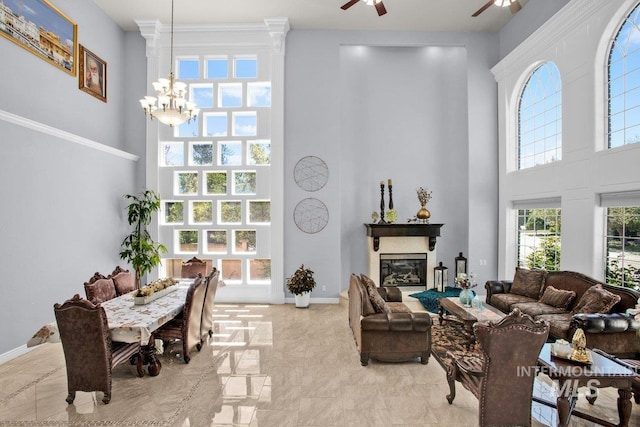 living room featuring a towering ceiling and ceiling fan with notable chandelier