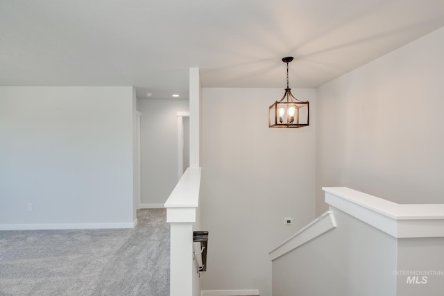 staircase with a chandelier, carpet flooring, and baseboards