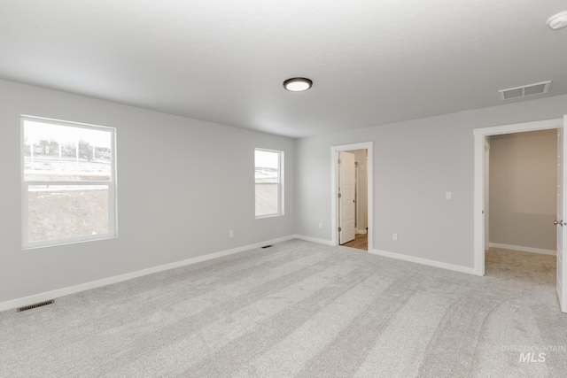 unfurnished room featuring light carpet, baseboards, and visible vents