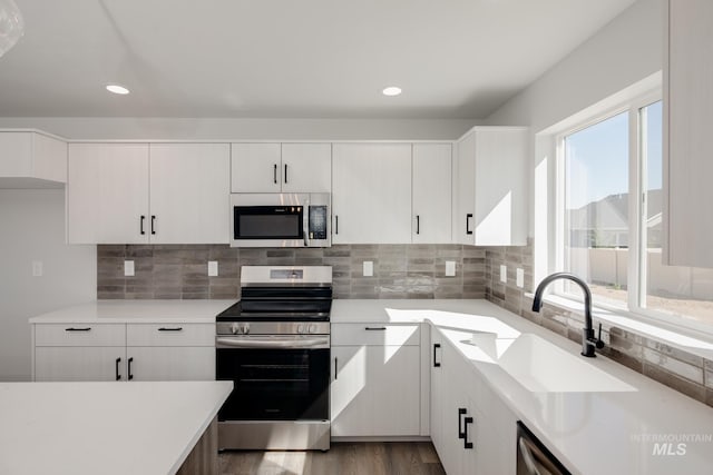 kitchen featuring stainless steel appliances, light countertops, and a sink