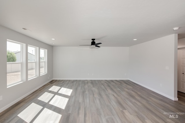 empty room with visible vents, baseboards, ceiling fan, wood finished floors, and recessed lighting