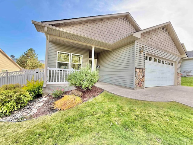 view of front of home featuring a porch, a front yard, and a garage