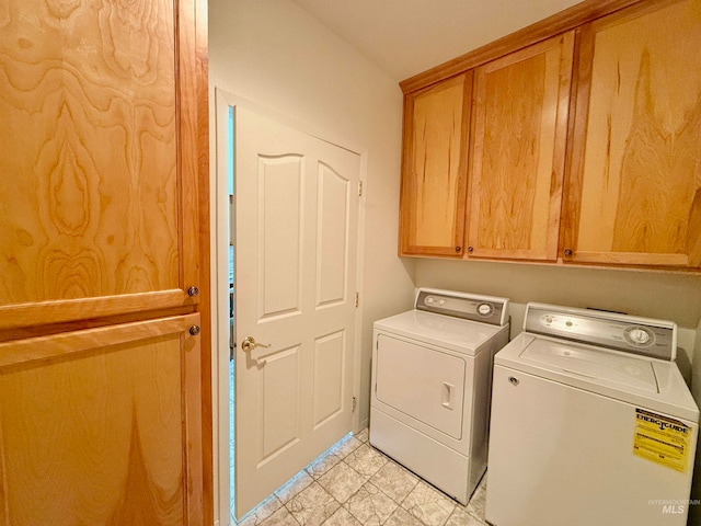 laundry room featuring washer and dryer, cabinets, and light tile patterned floors