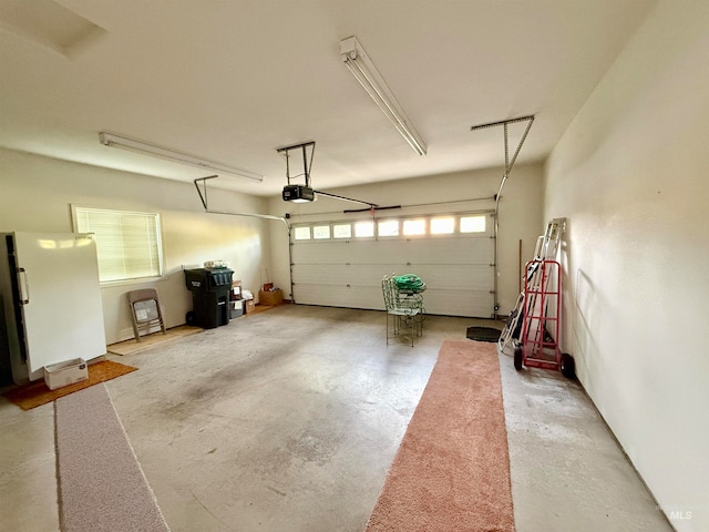 garage with a garage door opener and white fridge