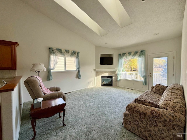 carpeted living room featuring vaulted ceiling with skylight, a textured ceiling, and a healthy amount of sunlight