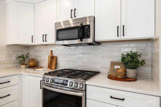 kitchen featuring decorative backsplash, white cabinetry, and stainless steel appliances