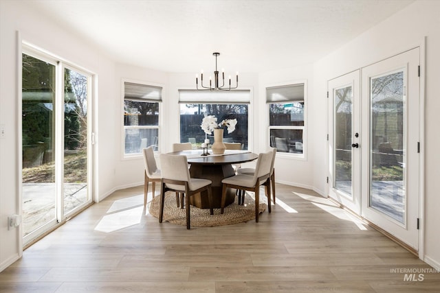 sunroom featuring french doors and a chandelier