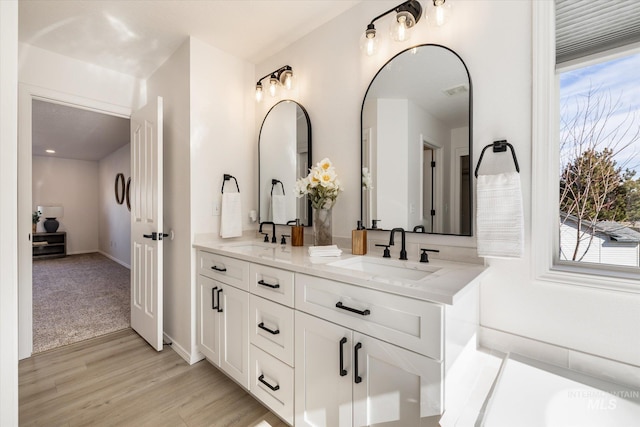 full bathroom featuring a sink, a healthy amount of sunlight, and double vanity