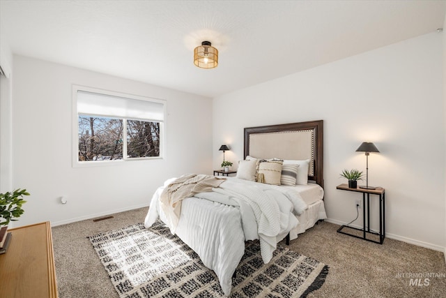 bedroom with visible vents, light carpet, and baseboards