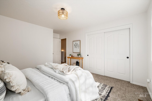 bedroom featuring a closet, light carpet, and baseboards