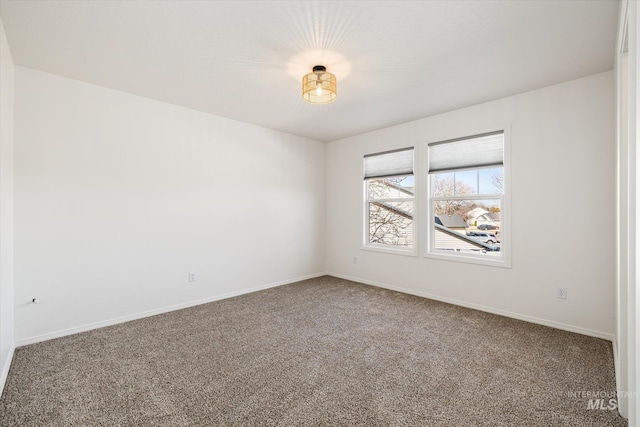 carpeted empty room with baseboards