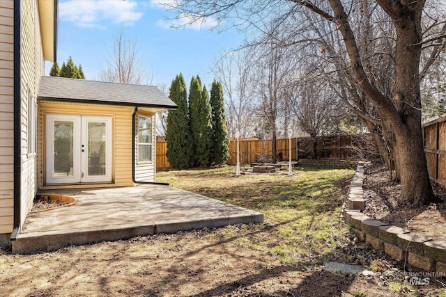 view of yard with french doors, a fire pit, a fenced backyard, and a patio