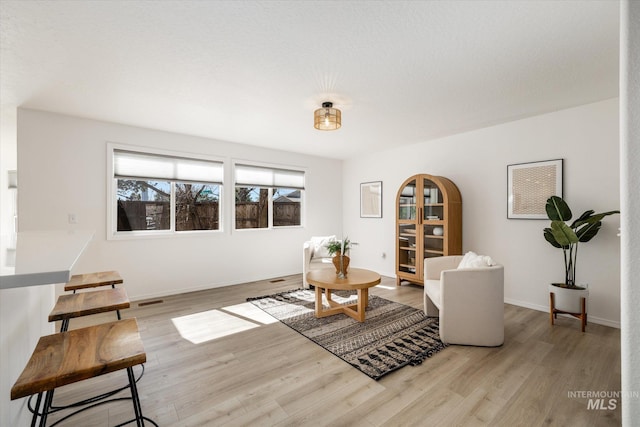 sitting room with baseboards and wood finished floors