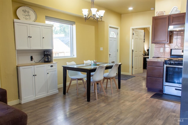 dining space featuring baseboards, an inviting chandelier, and dark wood-style flooring