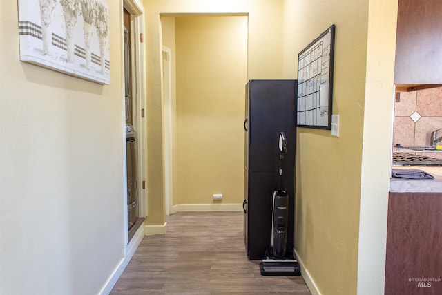 corridor featuring baseboards and wood finished floors