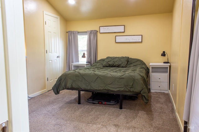 carpeted bedroom featuring baseboards and lofted ceiling