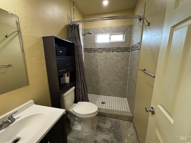 bathroom featuring vanity, a shower stall, and toilet