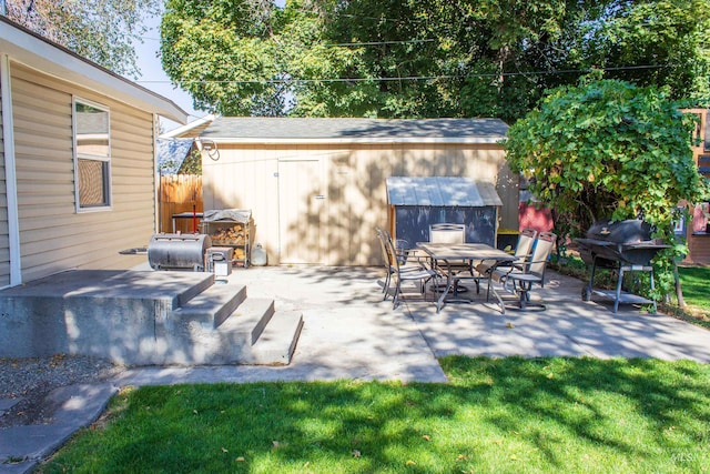 view of patio with outdoor dining space, fence, and grilling area