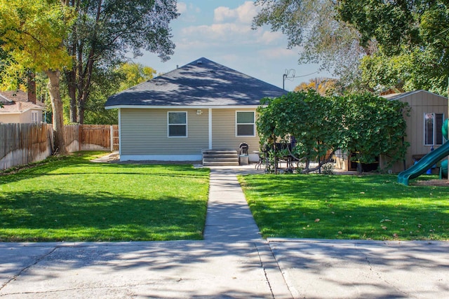 view of front facade with fence, a front yard, and a playground