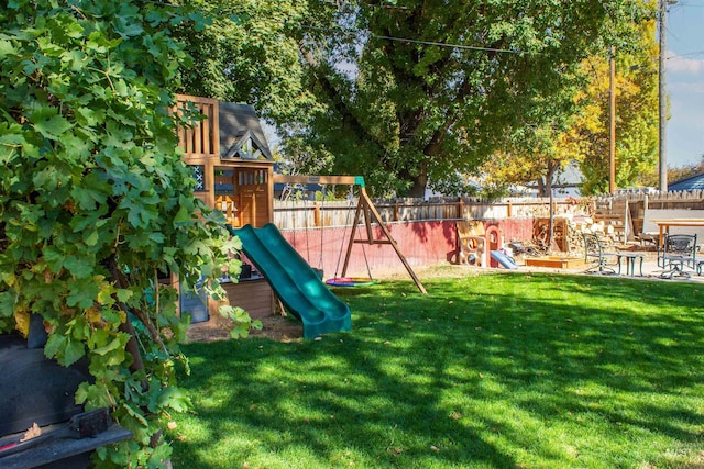 view of play area with a yard, a fenced backyard, and a patio area