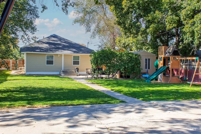 exterior space featuring a lawn, a playground, and fence