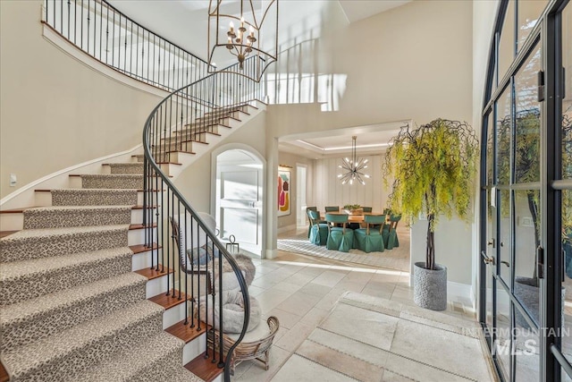 1122 W Two Rivers Ln, Eagle, ID 83616 - tiled entryway with a chandelier, stairway, a high ceiling, baseboards, and french doors