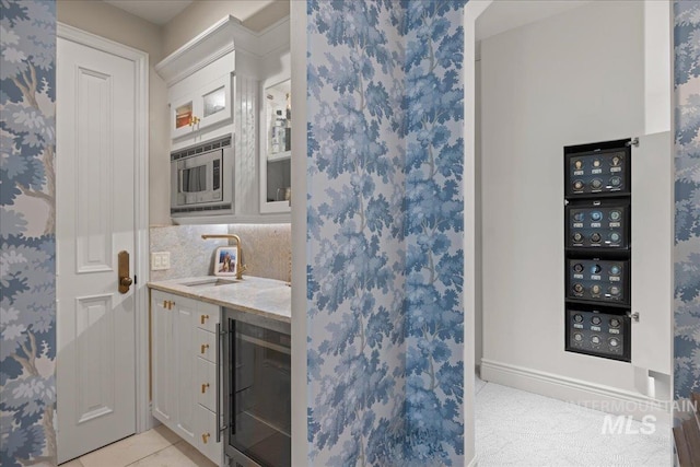 1122 W Two Rivers Ln, Eagle, ID 83616 - bar area featuring wine cooler, a sink, stainless steel microwave, light tile patterned floors, and tasteful backsplash