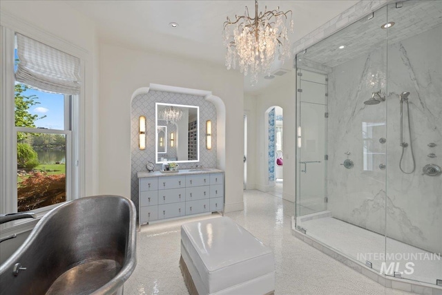1122 W Two Rivers Ln, Eagle, ID 83616 - full bathroom with a chandelier, a marble finish shower, vanity, a bathtub, and baseboards