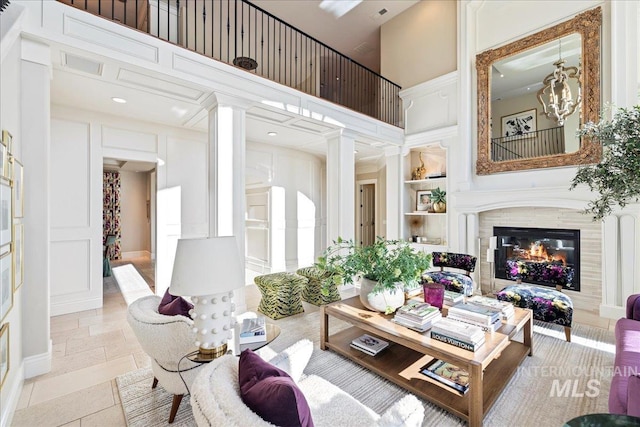 1122 W Two Rivers Ln, Eagle, ID 83616 - living area with a towering ceiling, ornate columns, a decorative wall, built in shelves, and a tile fireplace