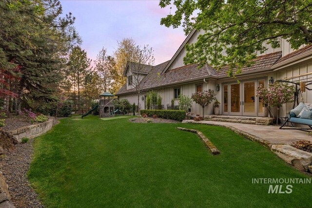 1122 W Two Rivers Ln, Eagle, ID 83616 - yard at dusk featuring a playground, french doors, a lawn, and a patio