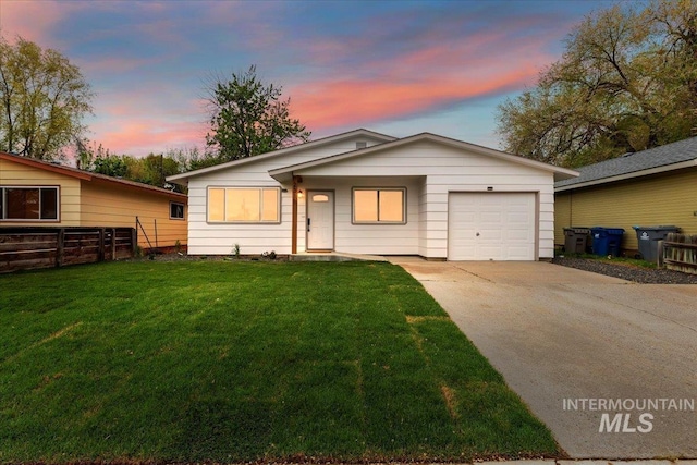 view of front of home featuring fence, driveway, a front yard, and a garage