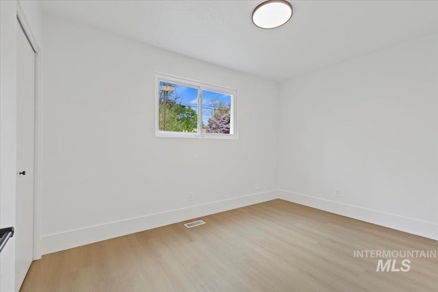 unfurnished bedroom featuring baseboards, a closet, light wood-type flooring, and visible vents