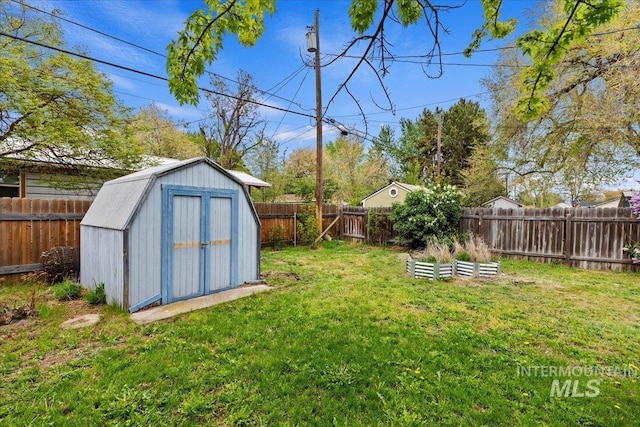 view of yard with a storage unit, a fenced backyard, and an outdoor structure