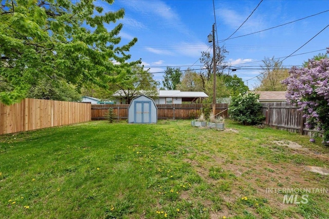 view of yard featuring a fenced backyard, a storage unit, and an outdoor structure