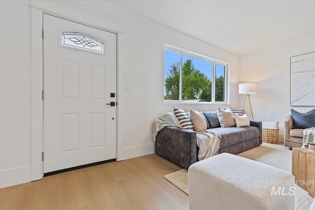 living area featuring light wood-style floors and baseboards