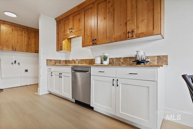 kitchen featuring white cabinets, light wood finished floors, dishwasher, brown cabinetry, and dark stone countertops