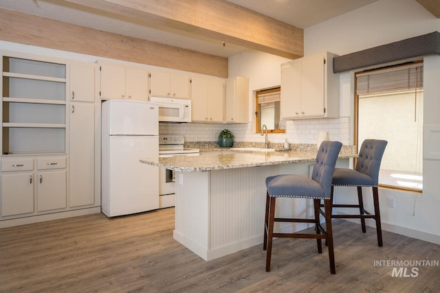 351 S 2nd Ave Unit 602, Ketchum, ID 83340 - kitchen featuring white appliances, decorative backsplash, white cabinets, light wood-style floors, and beam ceiling