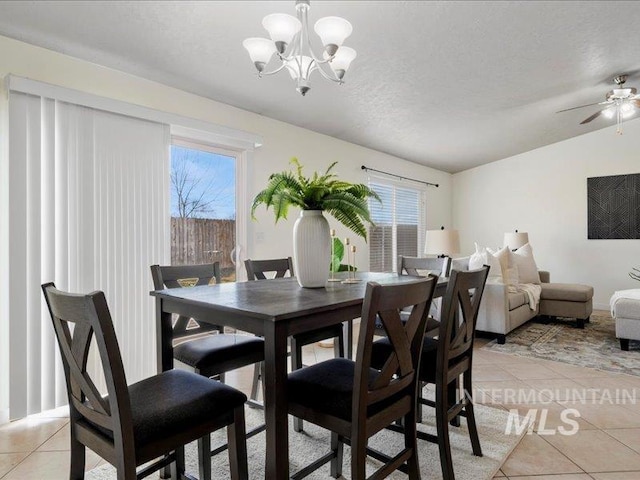 dining space with light tile patterned floors, a healthy amount of sunlight, and a textured ceiling