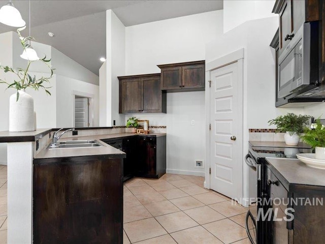 kitchen featuring a sink, stainless steel range with electric cooktop, dark brown cabinetry, a peninsula, and light tile patterned floors
