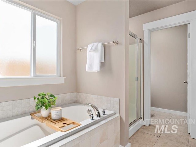 full bathroom with a bath, a shower stall, and tile patterned flooring
